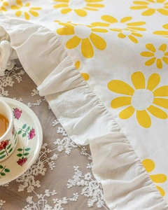 Detail of yellow floral cotton fabric with elegant ruffle edge and rustic texture