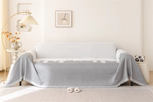 Detail of chenille sofa throw featuring wave patterns and fine fringed edges for home decor