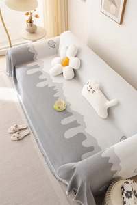 Detailed knit of Nordic chenille sofa cover with abstract cat motif and fringed edges