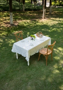 Detail of white cotton tablecloth with colorful dots and ruffled skirt edge in outdoor light