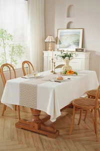 Détail de nappe nordique blanche avec chemin de table à chevrons beige et motifs géométriques