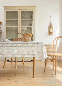 Detail einer beigen Vintage-Jacquard-Tischdecke mit eleganten Quastenkanten und Stickerei