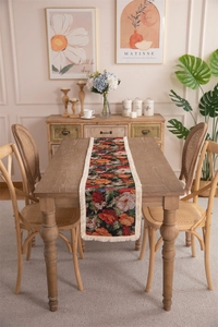 Close-up of floral jacquard table runner with delicate cream tassels and woven patterns