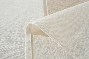 Gros plan sur la nappe jacquard nordique avec motif de losanges beige et texture en zigzag