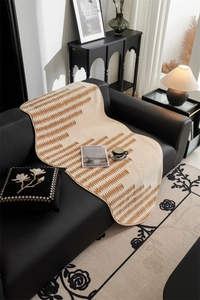 Close-up of jacquard sofa cover with geometric patterns on black leather furniture