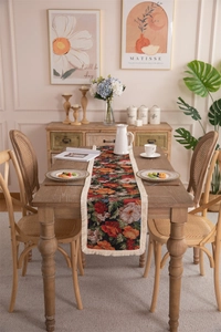Close-up of vintage floral jacquard table runner with cream fringe on a wooden table