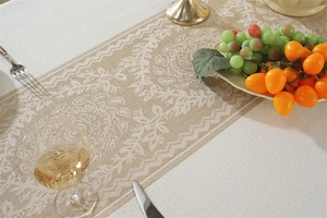 Détail du chemin de table jacquard beige avec bords ondulés et motifs floraux raffinés