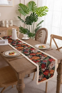 Macro view of floral jacquard table runner with delicate tassels on a wooden table