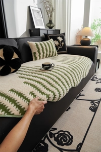 Close-up of thick jacquard sofa cushion with green leaf patterns and soft chenille texture