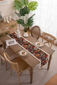 Macro detail of dark green jacquard table runner with vintage floral pattern and white fringe