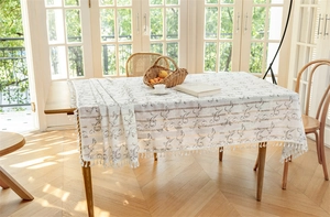 Detailansicht der weißen rechteckigen Tischdecke mit grauen Mustern und Quastenkante
