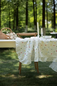 Close-up of geometric embroidery and elegant ruffle edge on a French cotton tablecloth