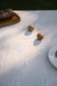 Detail of white 3D floral embroidery on French style cotton lace tablecloth fabric