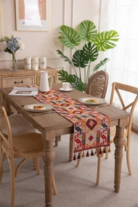 Close-up of bohemian table runner with colorful geometric patterns and handmade tassels