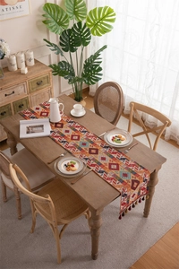 Bohemian woven table runner featuring vibrant geometric patterns and colorful tassels