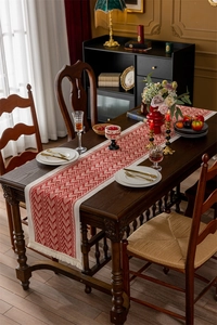 Detail of red and white jacquard table runner with geometric patterns and tassels