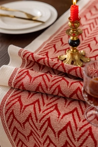 Detail of red and cream geometric jacquard table runner with thick woven texture