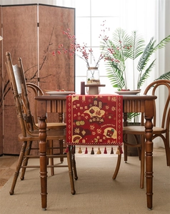 Close-up of red Chinese New Year table runner featuring floral jacquard and tassels