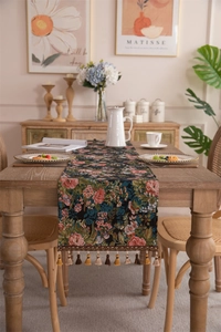 Detail showing vintage floral jacquard table runner with hanging tassel trim and roses