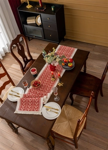 Detail of red and white chevron jacquard table runner with decorative tassel fringe