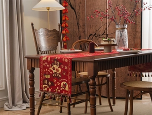 Detail of red festive Chinese New Year table runner with tassels and jacquard texture
