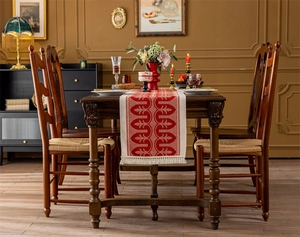 Close-up of red and white jacquard table runner with leaf pattern and white tassels