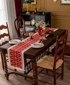 Close-up of vintage red and beige jacquard table runner with decorative white tassels