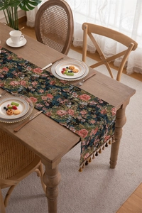 Detailed texture of jacquard floral table runner with vintage tassels on wooden table