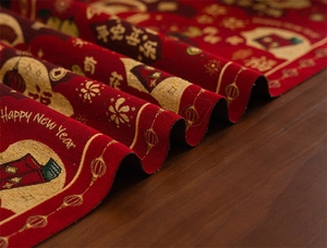 Macro detail of red festive table runner with golden New Year embroidery and jacquard texture