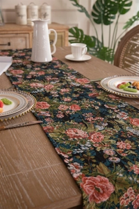 Close-up of vintage floral jacquard table runner with fringe and elegant tassel details