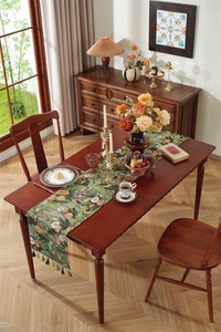Close-up of vintage sunflower jacquard table runner with decorative fringe on wood