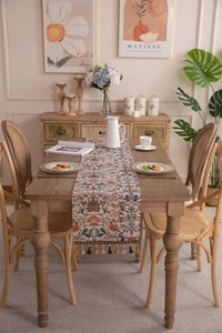 Detailed view of vintage jacquard table runner with flower patterns and fringe tassels