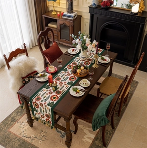 Detail of vintage floral table runner with colorful sunflower patterns and fringe