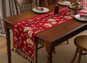Close-up of red festive table runner with tassels and traditional jacquard weaving patterns