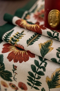 Close-up of jacquard floral table runner with red flowers and dark green border