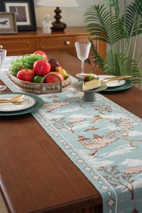 Détail d'un chemin de table en jacquard aux motifs de paysages et tons bleus orientaux