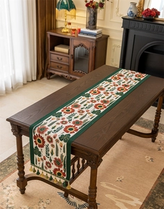 Detail of sunflower jacquard table runner with green trim and decorative tassels