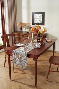 Close-up of vintage floral jacquard table runner with intricate tassels and mandala pattern