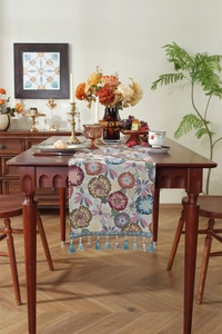 Macro shot of jacquard table runner with vintage floral patterns and tassel fringe details