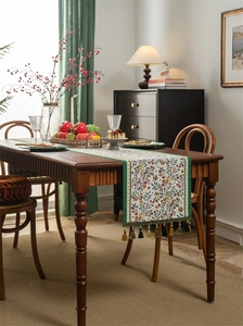Close-up of floral bird jacquard table runner with vintage green tassel fringe detail