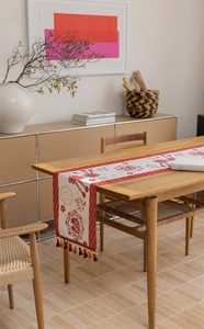 Detailed view of Chinese jacquard table runner with red tassels and golden patterns
