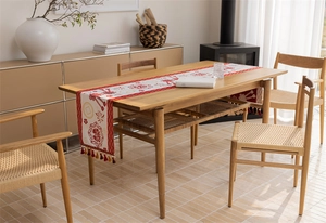 Close-up of red Chinese table runner with jacquard patterns and elegant tassel edge