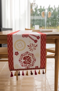Detail of red and white Chinese festive table runner with traditional patterns and colorful tassels