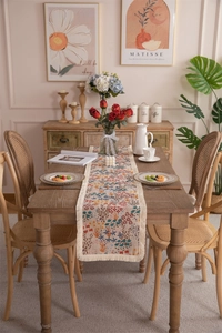 Detailed close-up of beige cotton floral table runner with ethnic tassels and fringe