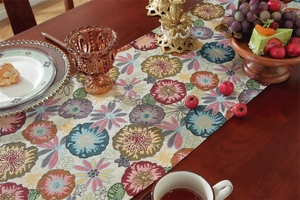 Close-up of floral jacquard table runner with vintage plant patterns and tassel texture