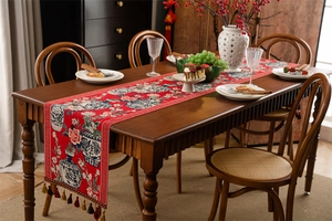 Détail du chemin de table en jacquard rouge avec motifs de pivoines et bordure à glands