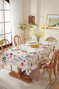 Detail of vibrant floral Easter tablecloth featuring elegant white tassel fringe borders