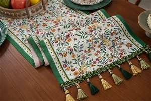 Close-up of vintage jacquard table runner with bird floral patterns and silk tassels