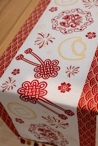 Close-up of jacquard fabric table runner with red wave borders and Chinese festive motifs