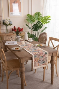 Detail of colorful floral jacquard pattern and thick white tassel fringe on table runner